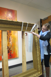 Collections Manager Sabena carefully wraps the frame for transportation.